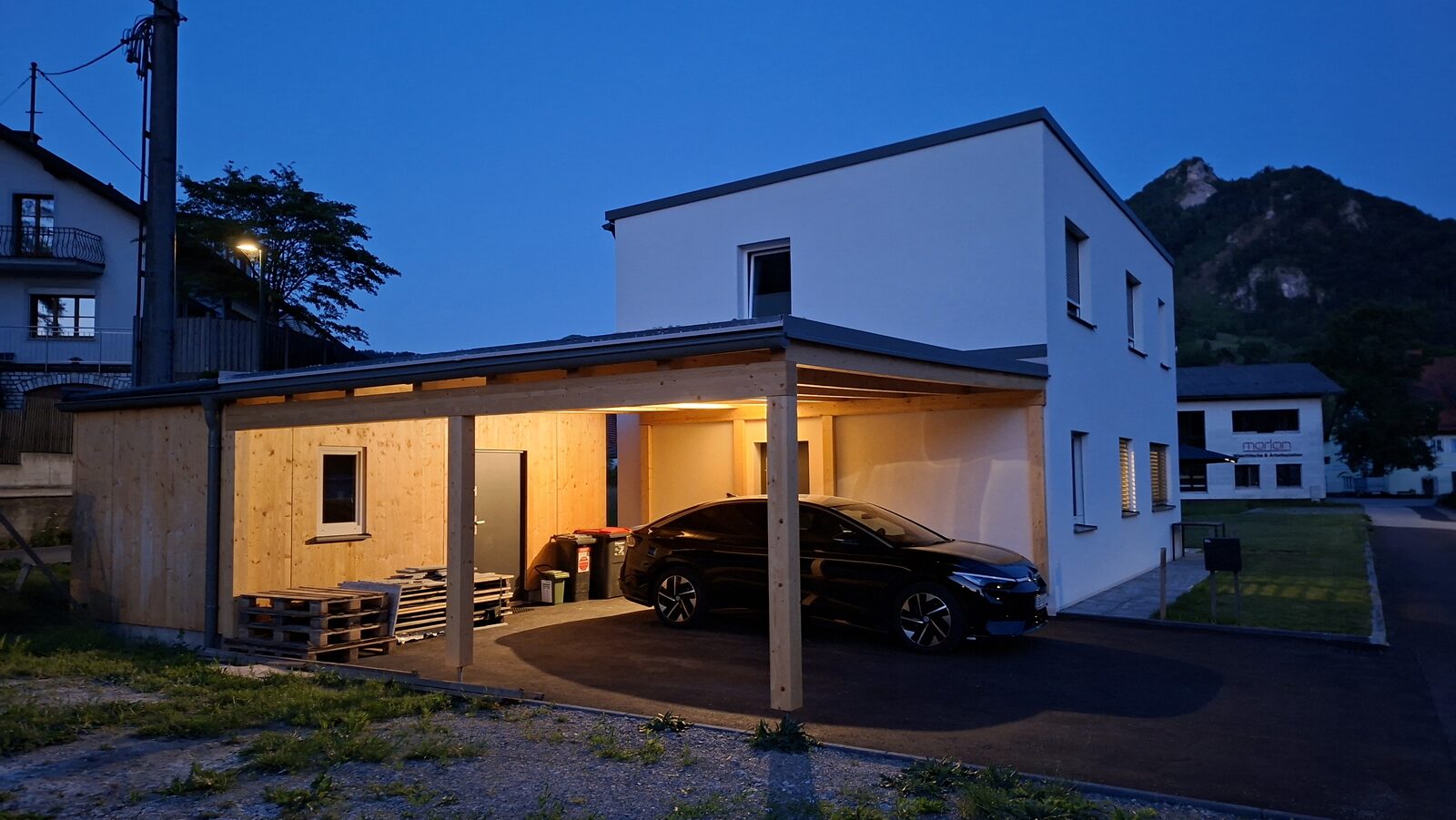 Einfamilienhaus Losenstein mit beleuchtetem Carport in der Abenddämmerung