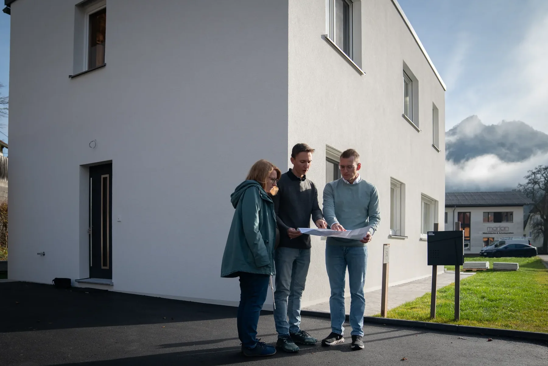 Bmst. Ing. Raffael Traxler mit den Bauherren am Tag der Schlüsselübergabe vor ihrem Einfamilienhaus in Losenstein